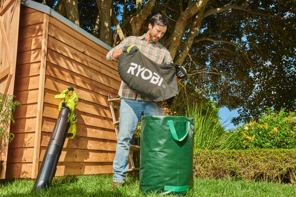 Mężczyzna wyrzuca liście z worka odkurzacza ogrodowego RYOBI