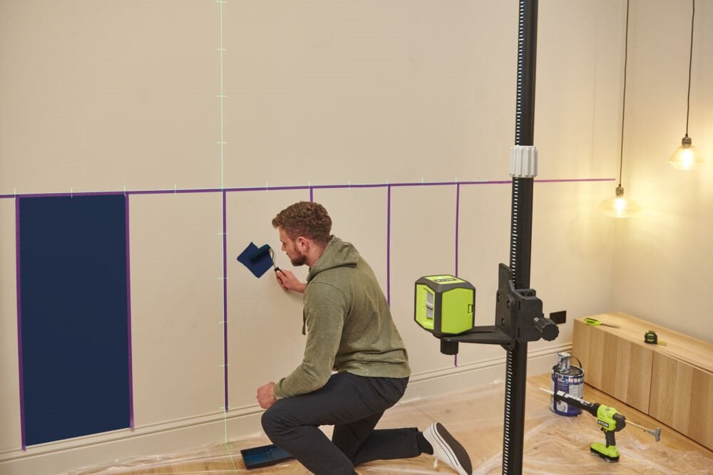 Mężczyzna maluje ściany na niebiesko w kuchni