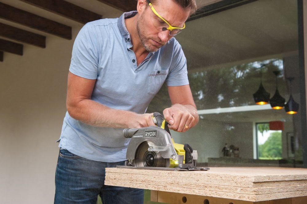 Mężczyzna docina meble kuchenne pilarką tarczową akumulatorową