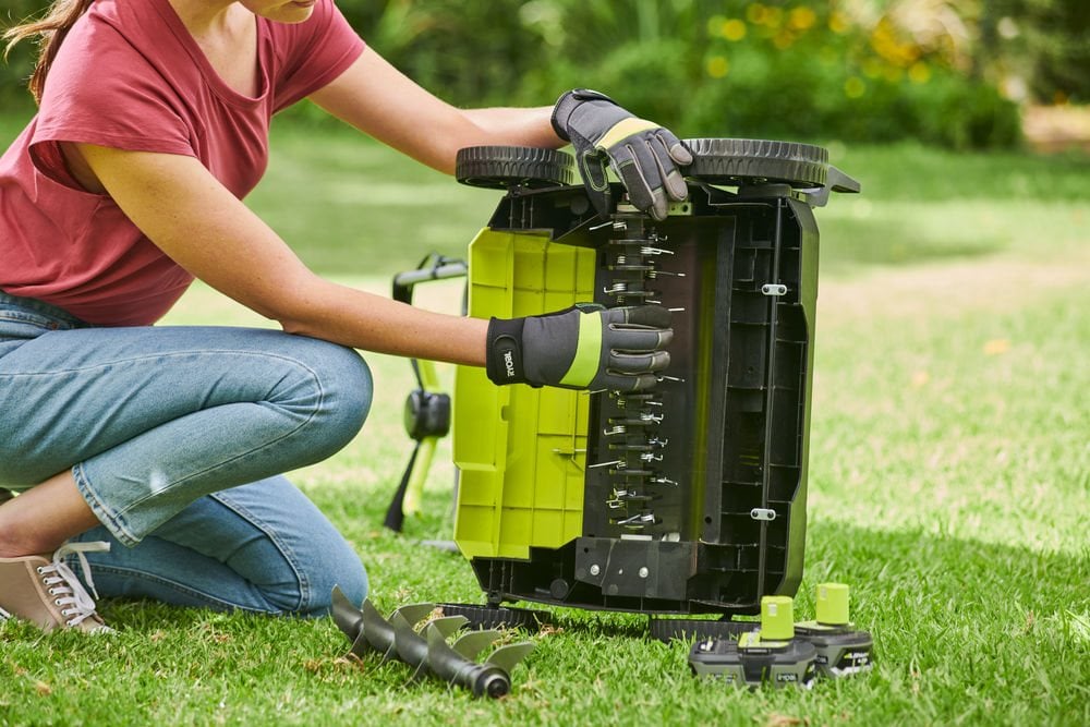 Kobieta przygotowuje wertykulator do wiosennych prac w ogrodzie