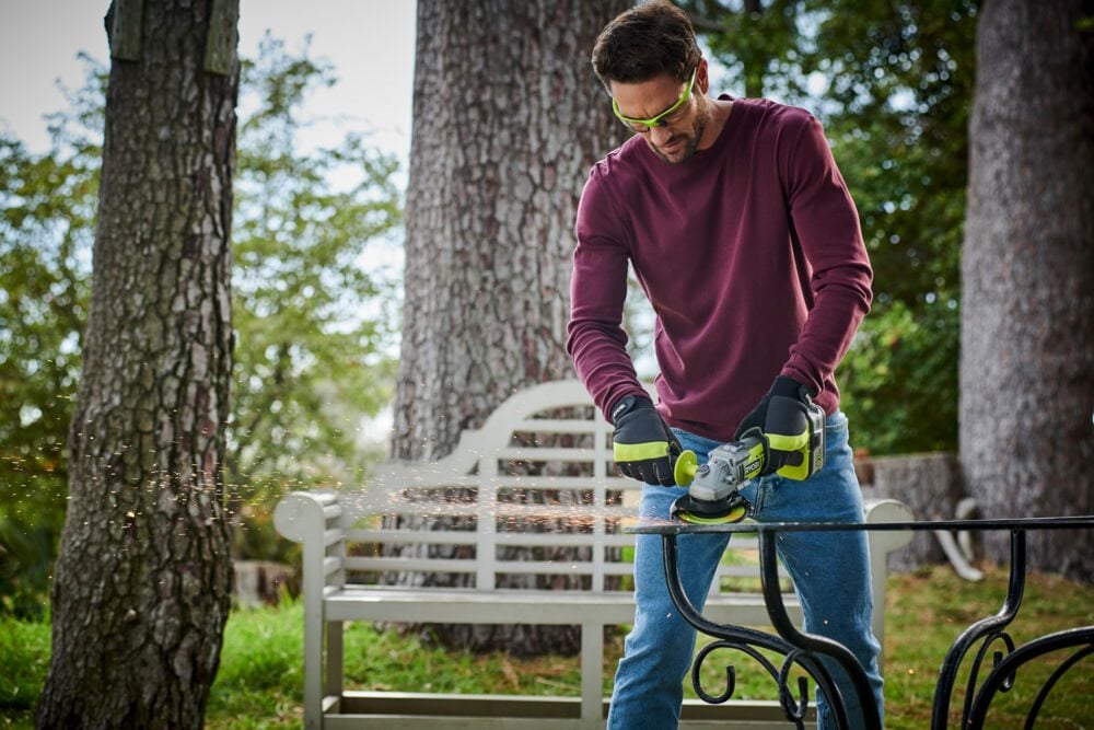 Mężczyzna używa szlifierki kątowej do pracy z metalem