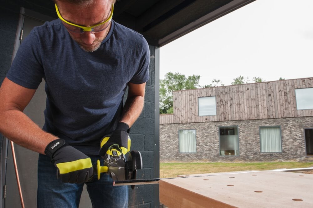 Mężczyzna używa szlifierki kątowej RYOBI 18V