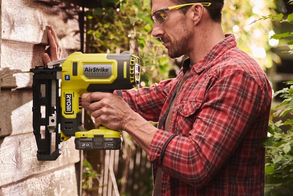 Mężczyzna używa sztyfciarki 16G 18V do budowy drewutni